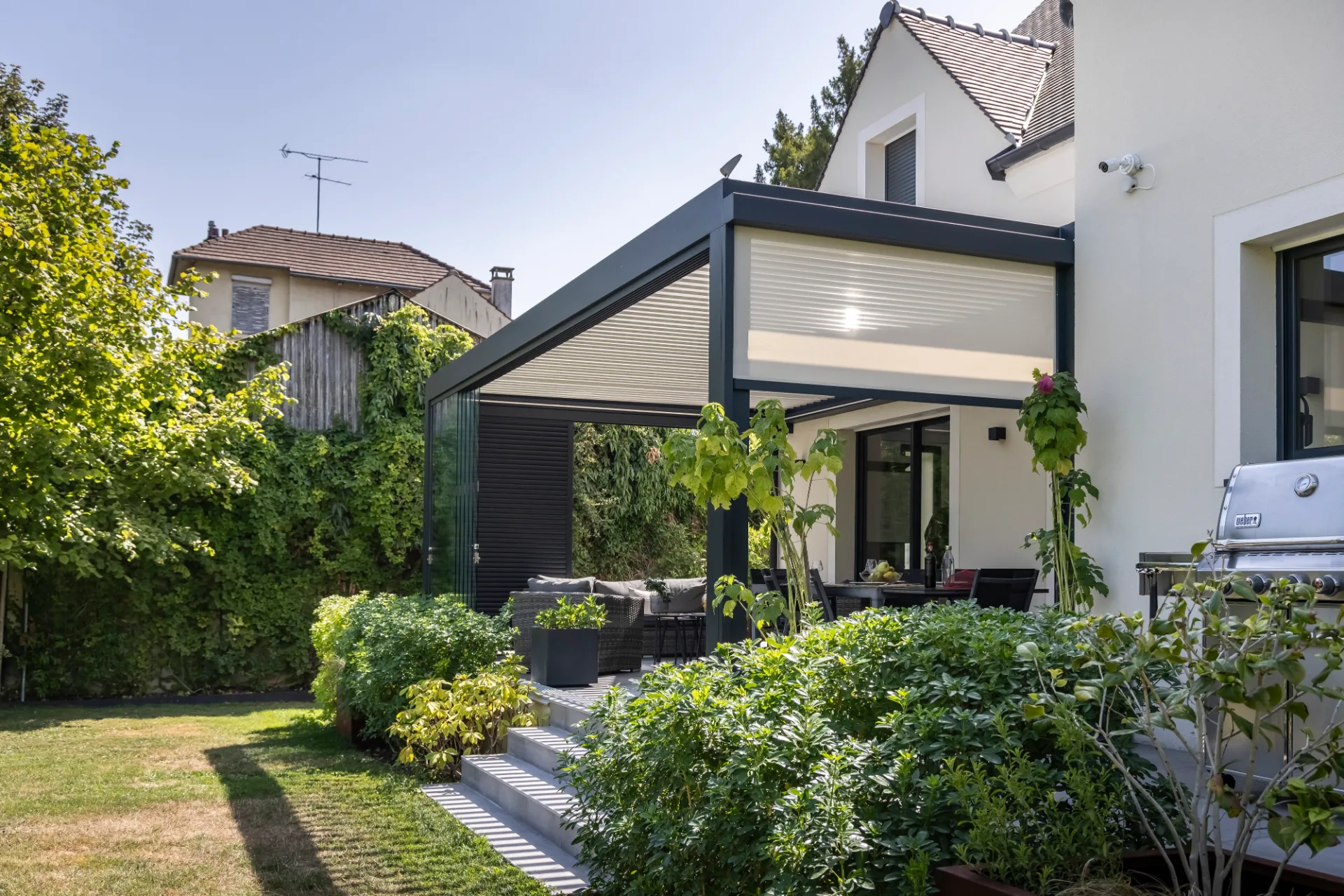 Pergola bioclimatique Biossun équipée de store, vitrage et claustra